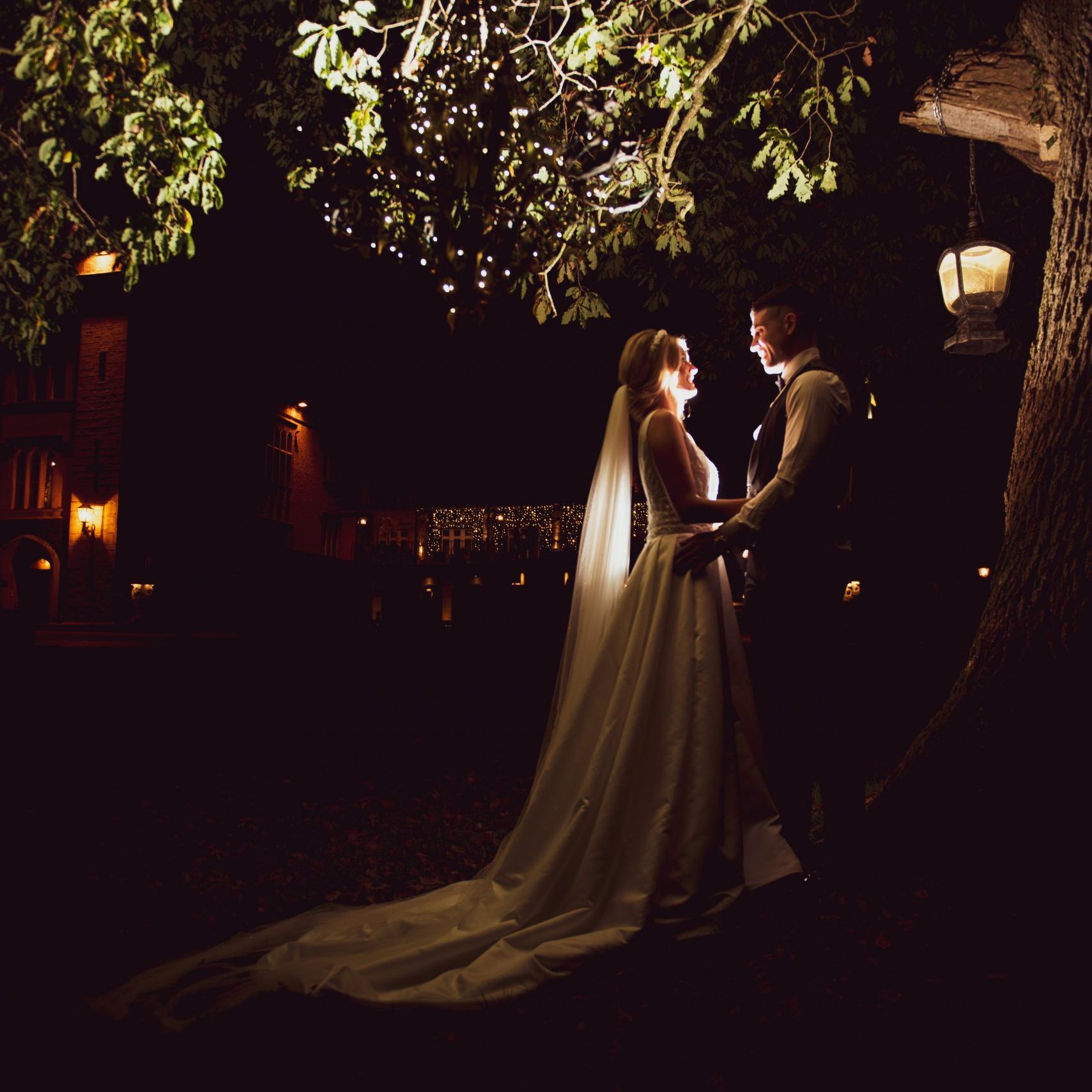 Shot of newlyweds taken under a tree at Cabra Castle at night - photo by Ciaran O'Neill Photography