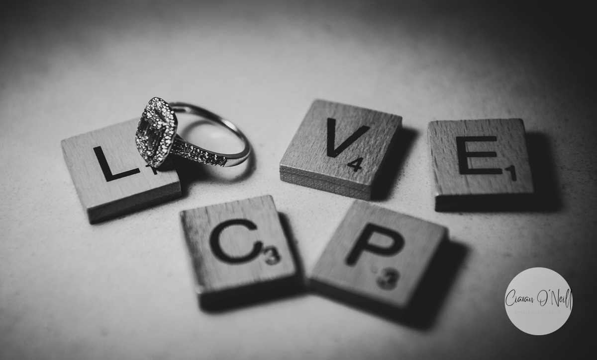 Birde's engagement ring completing the scrabble letter to spell LOVE