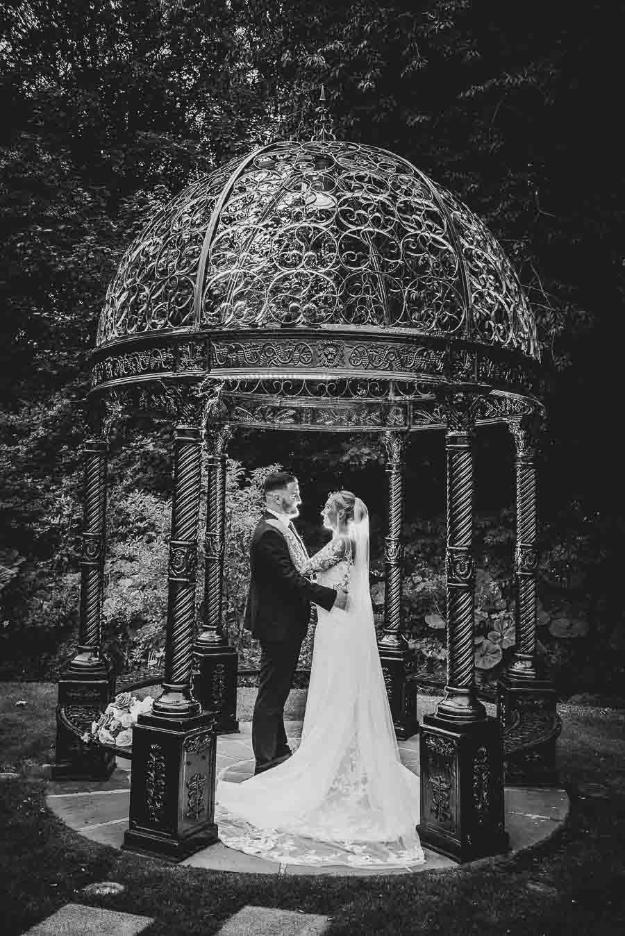 Bride & groom standing under gazebo at Ballygally Castle