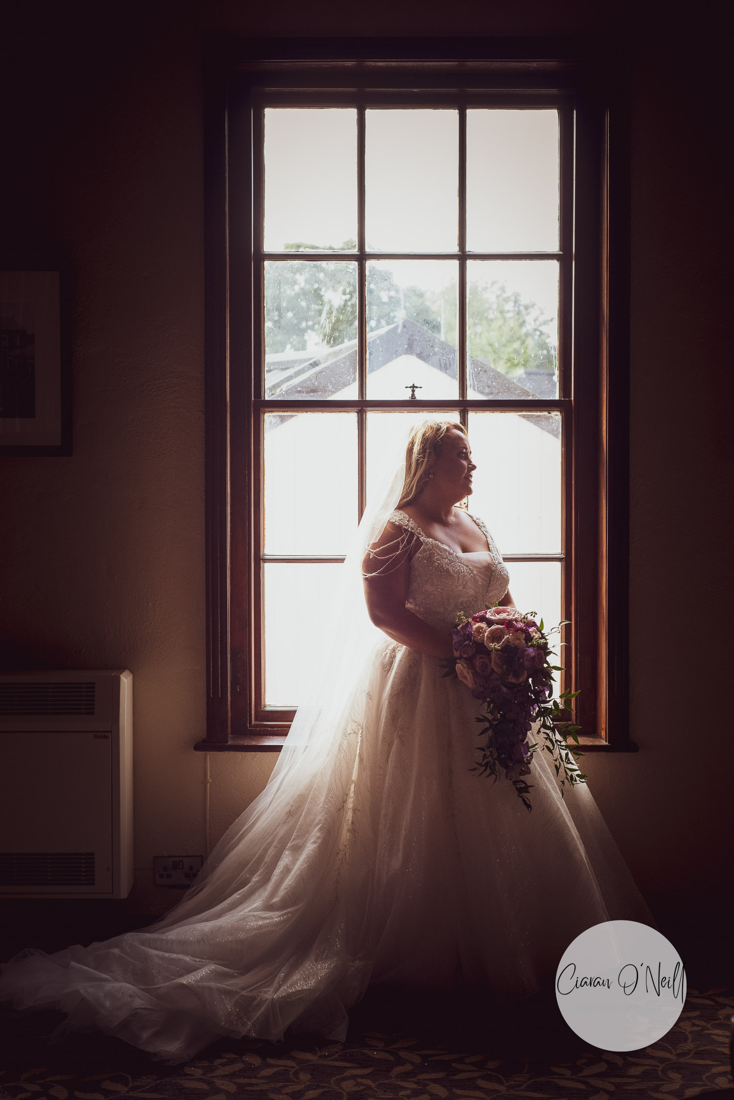 Claire standing, silhouetted by the window