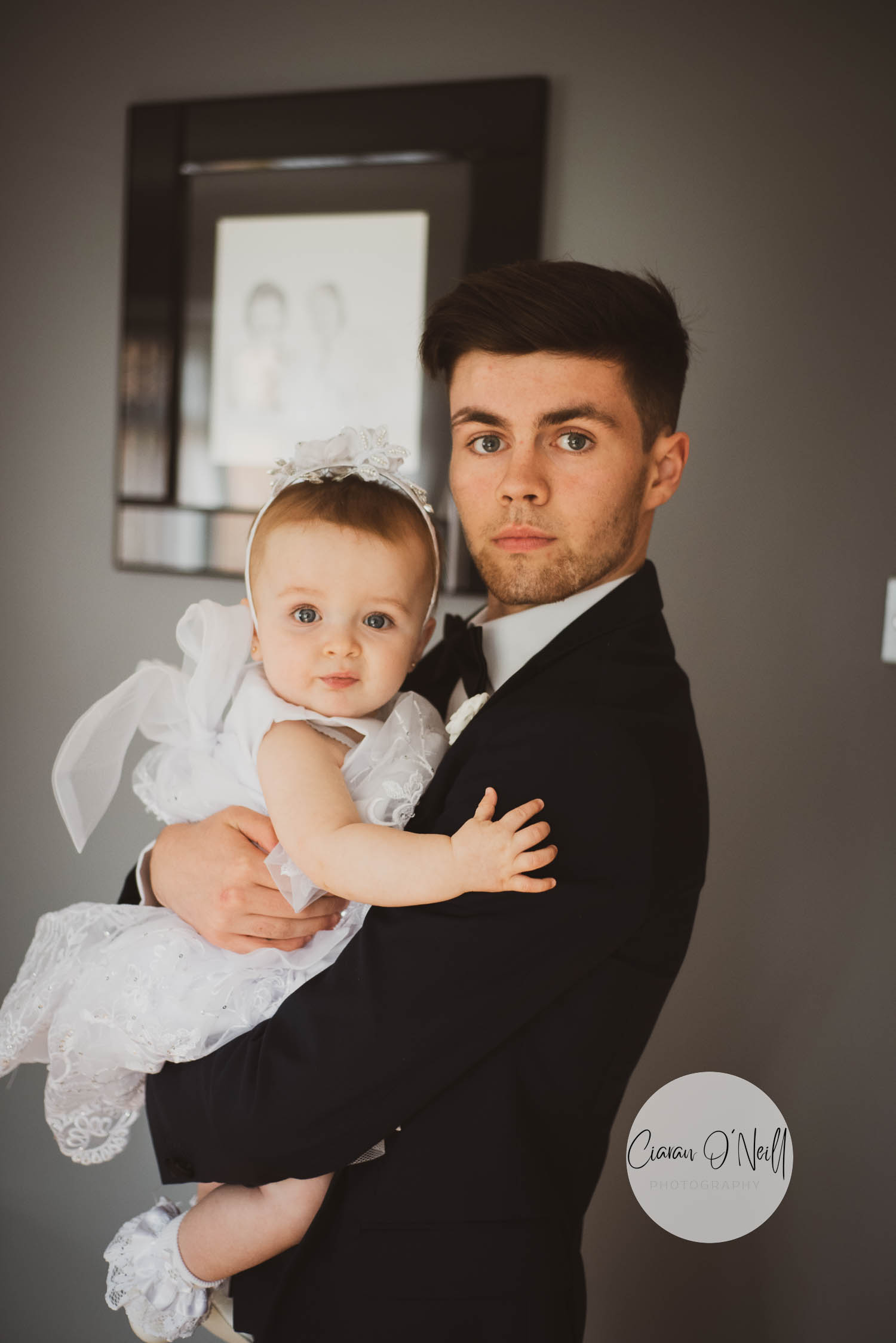 Groomsman holding the flowergirl before the start of the wedding