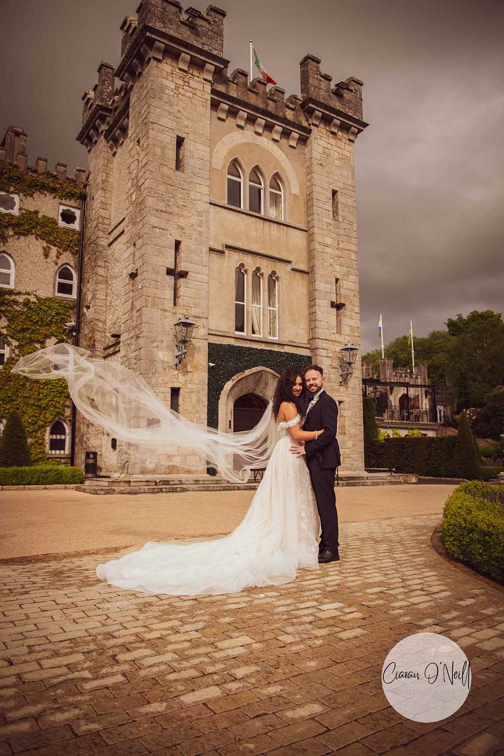 Bride & Groom standing embracing in front of the Cabra Castle main entrance