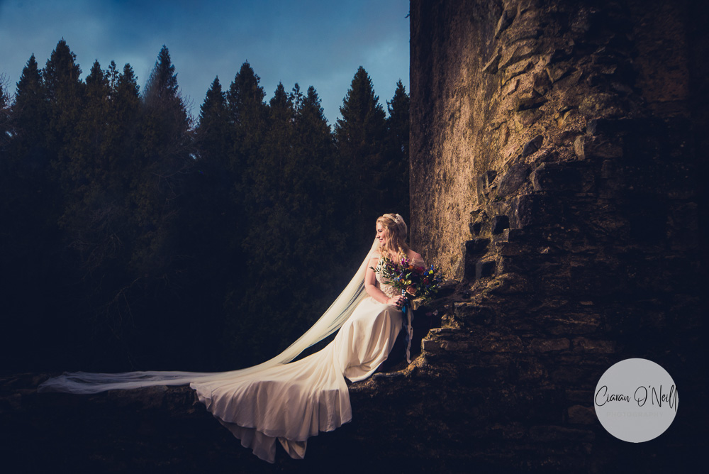 Bride lying on a stone wall in Old Castle Archdale ruins