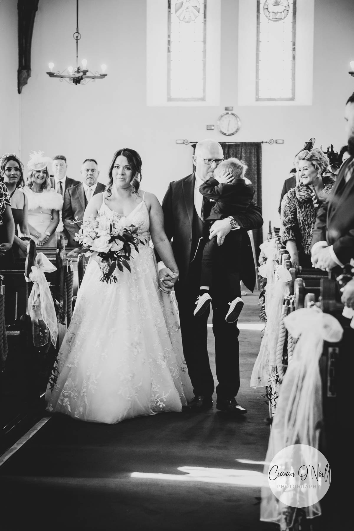 Bride, her father and her son walk down the aisle