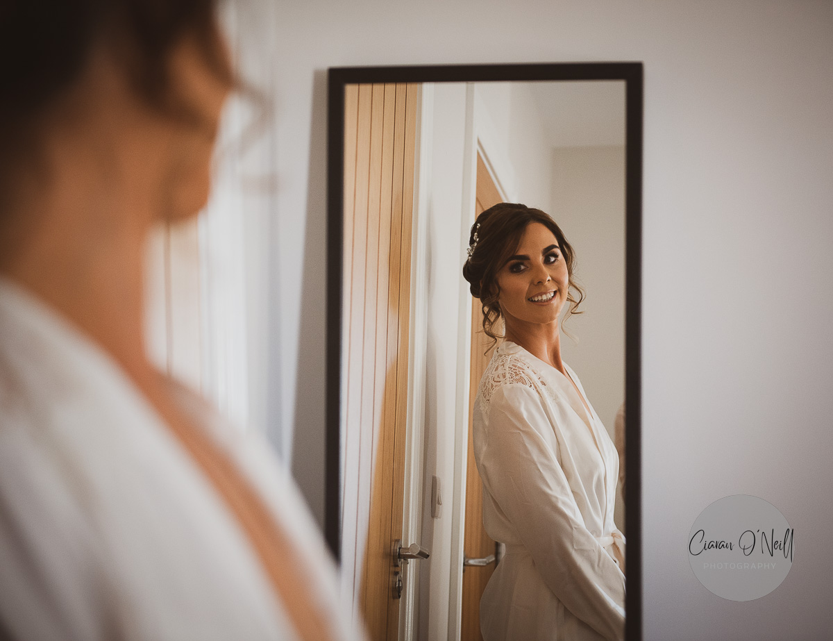 Bride looking at herself in the mirror during the bridal prep