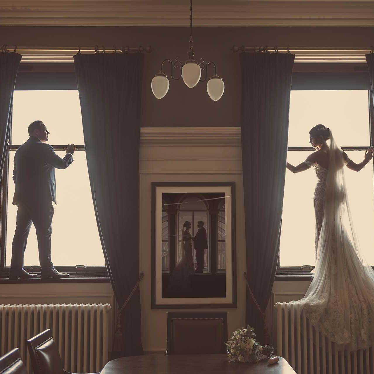 Titanic Hotel Wedding - Robyn & David standing in the window frames of the Ballroom