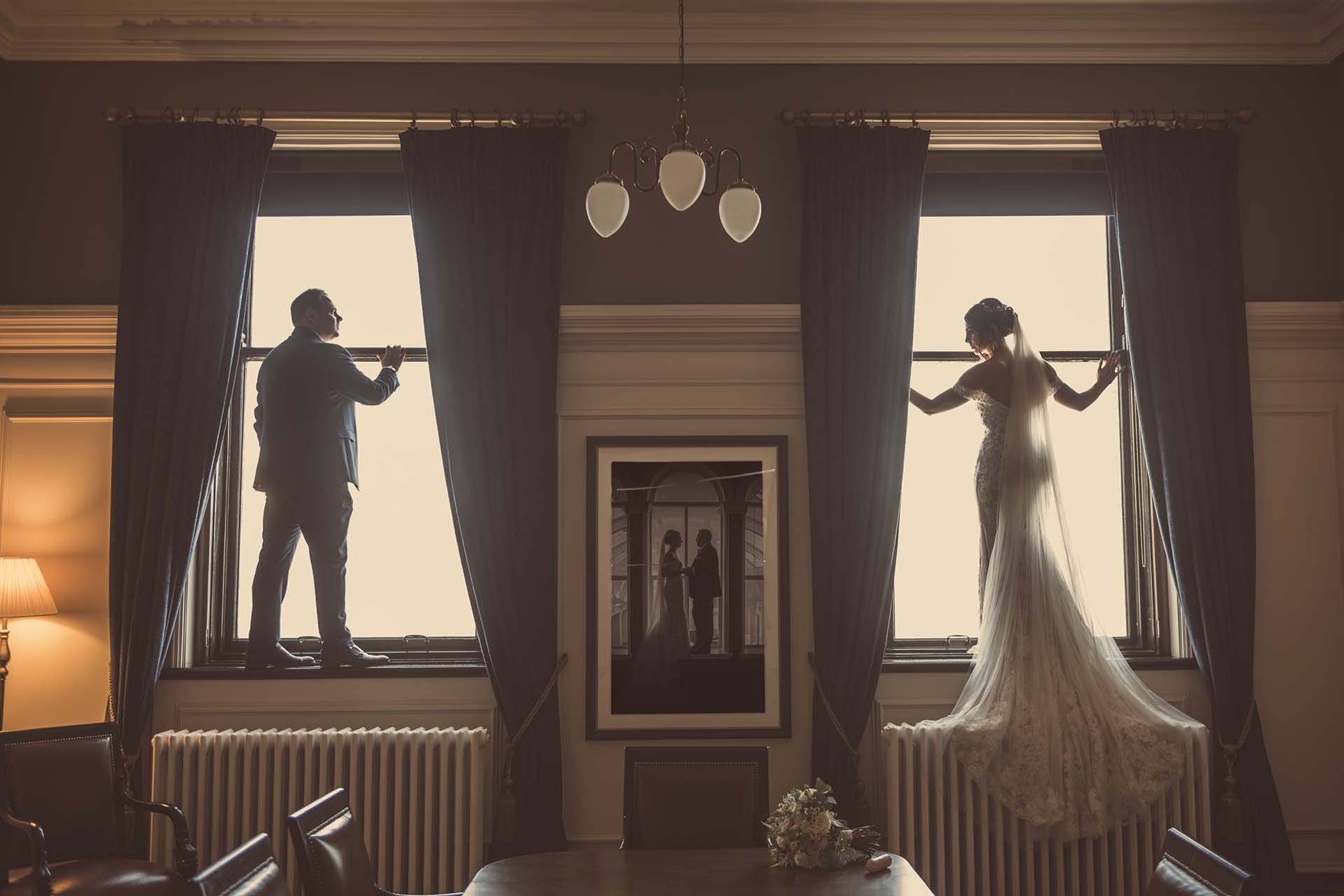 Titanic Hotel Wedding - Robyn & David standing in the window frames of the Ballroom
