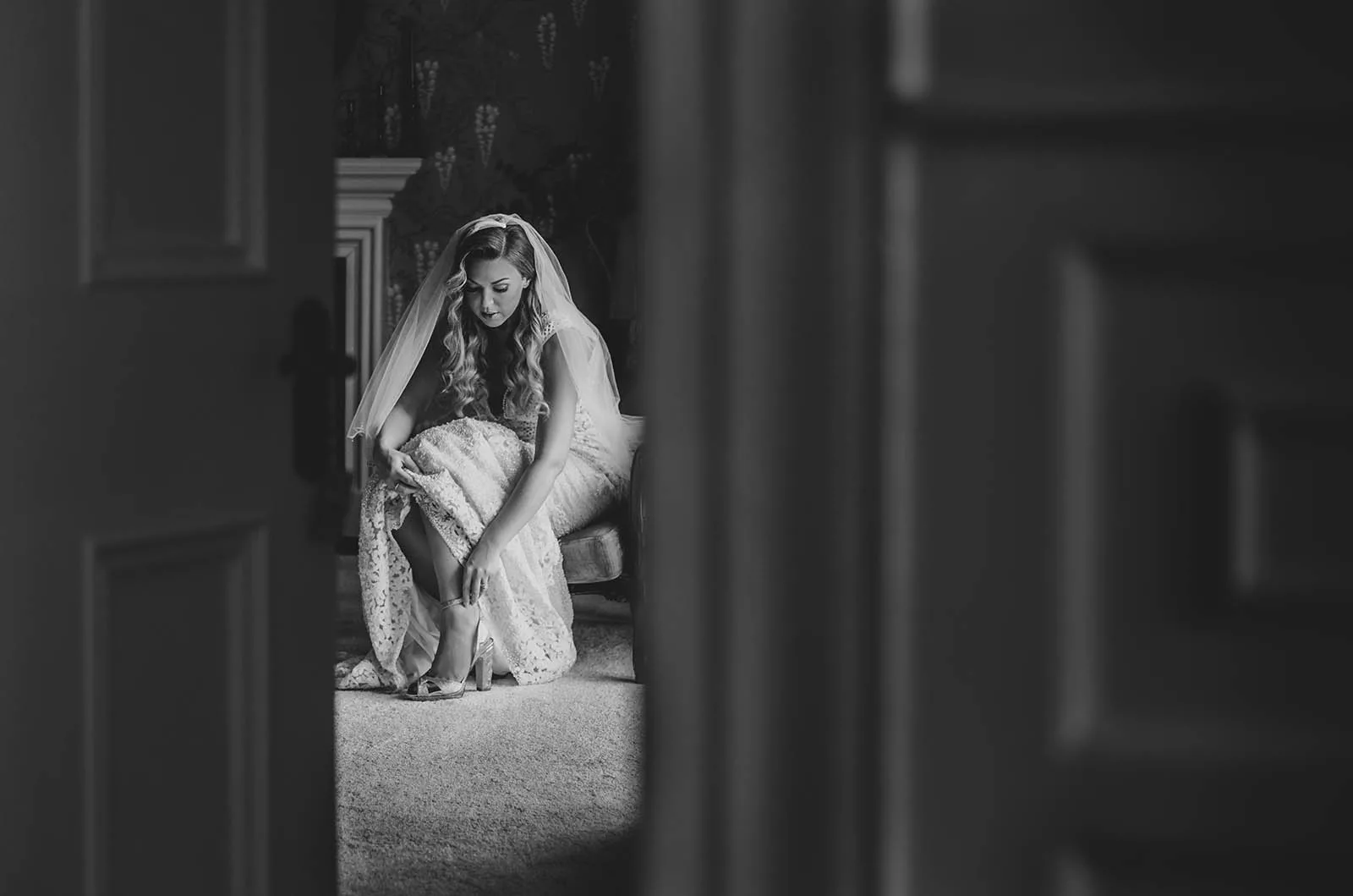 Shot of a bride fixing her shoe in the Darver Castle bridal suite Wedding Photographers Northern Ireland - Ciaran & Simon