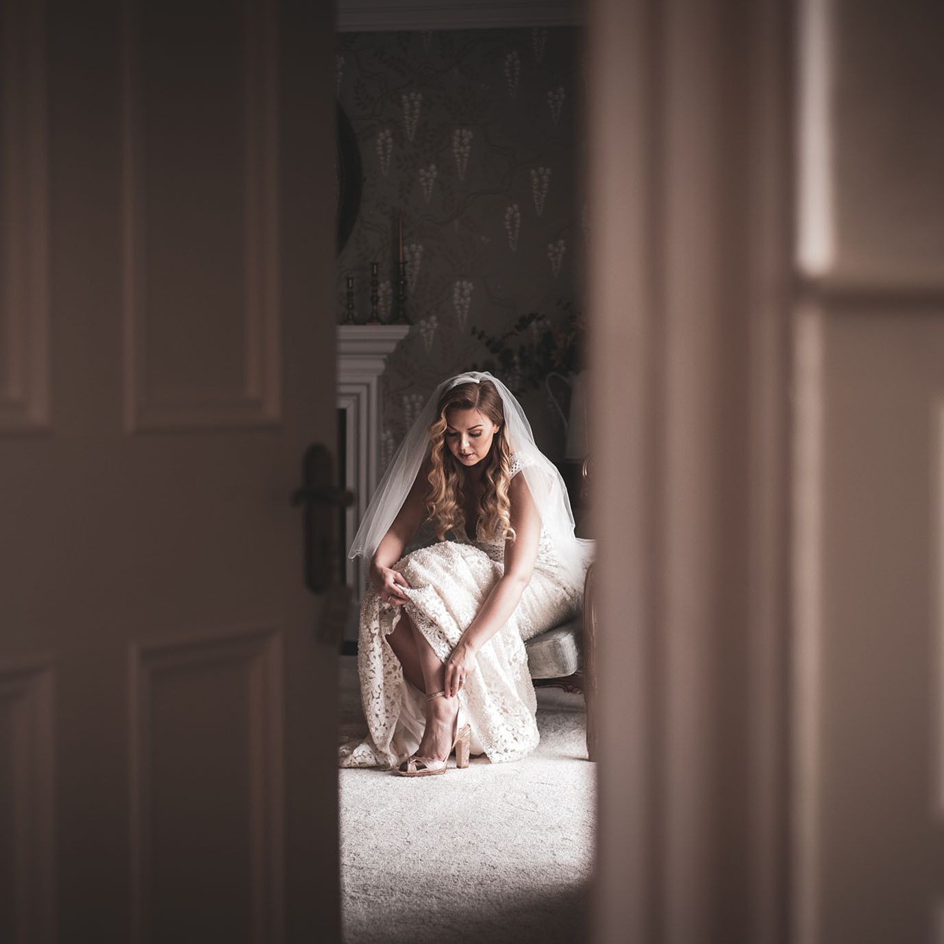 Bride fixing her shoe in the bridal suite at Darver Castle