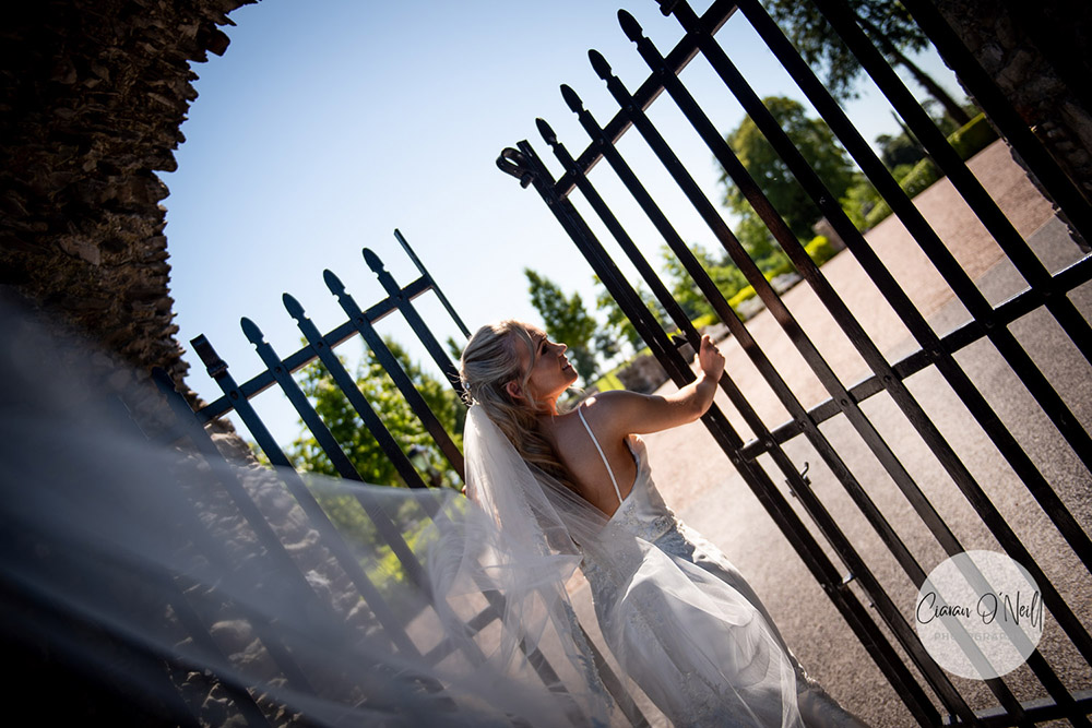 Bride pushing through iron gate at Darver Castle