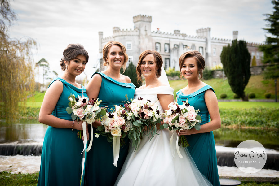 Bridesmaids and Bride pose for a photo with Bellingham Castle in the background