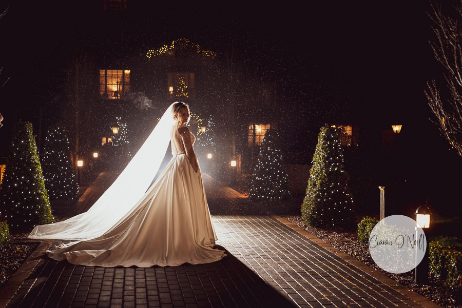 Bride standing outside Castle in darkness at Christmas time
