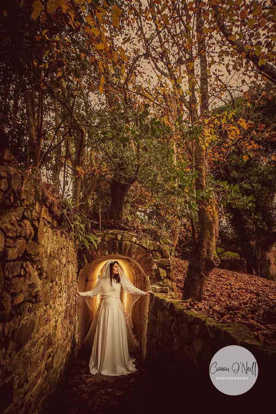 Autumn tones surround our a beautiful bride as she stands outside a tunnel