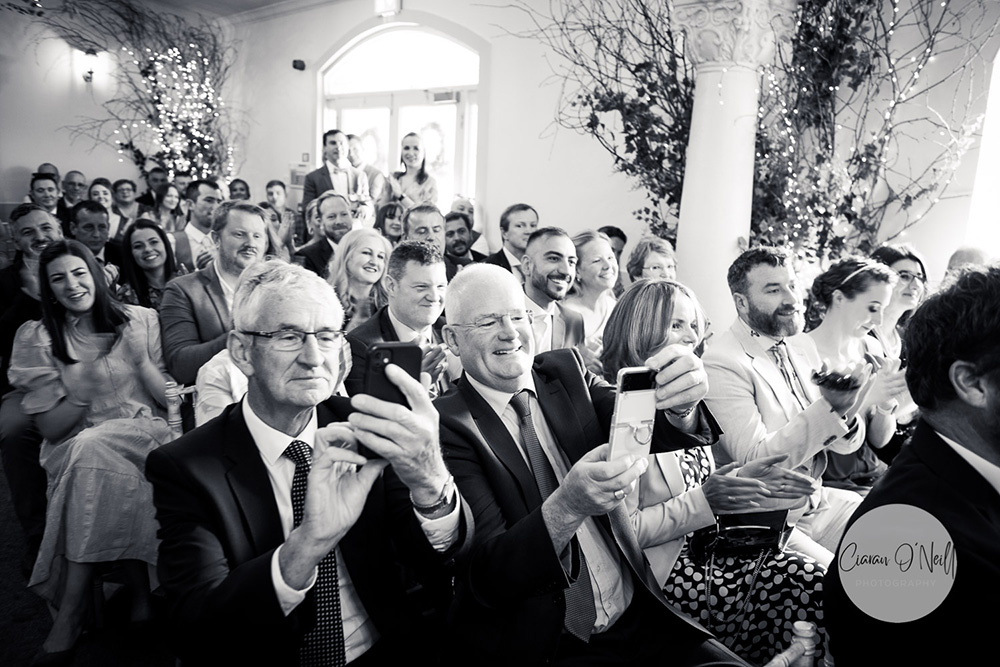 The guests applauding after the wedding service
