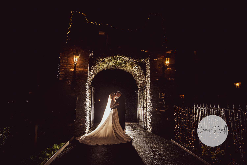 bride and groom at night under archway Darver Castle