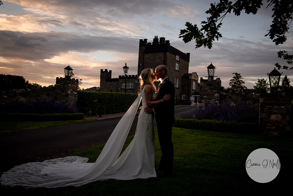 bride and groom at sunset with Darver Castle