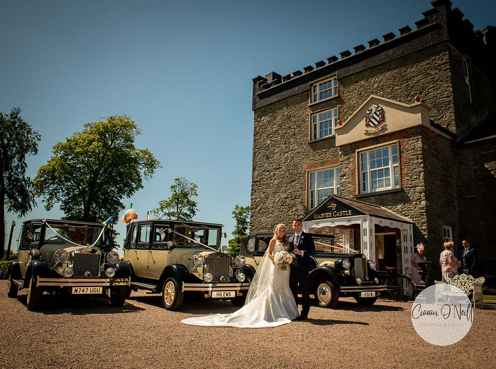 bride and groom with vintage style cars outside Darver Castle