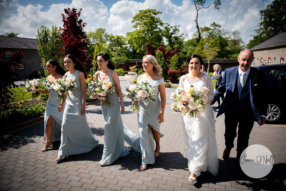 bride and party walk to ceremony room